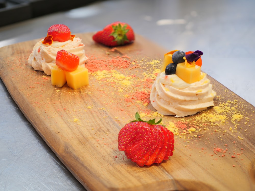 white and red cake with strawberry on brown wooden table