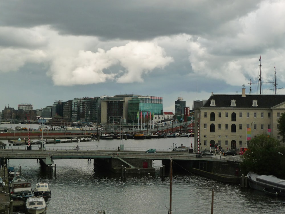 brown and white concrete buildings near body of water under white clouds during daytime