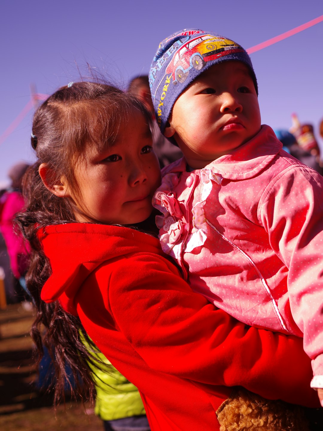 girl in red hoodie carrying girl in red jacket