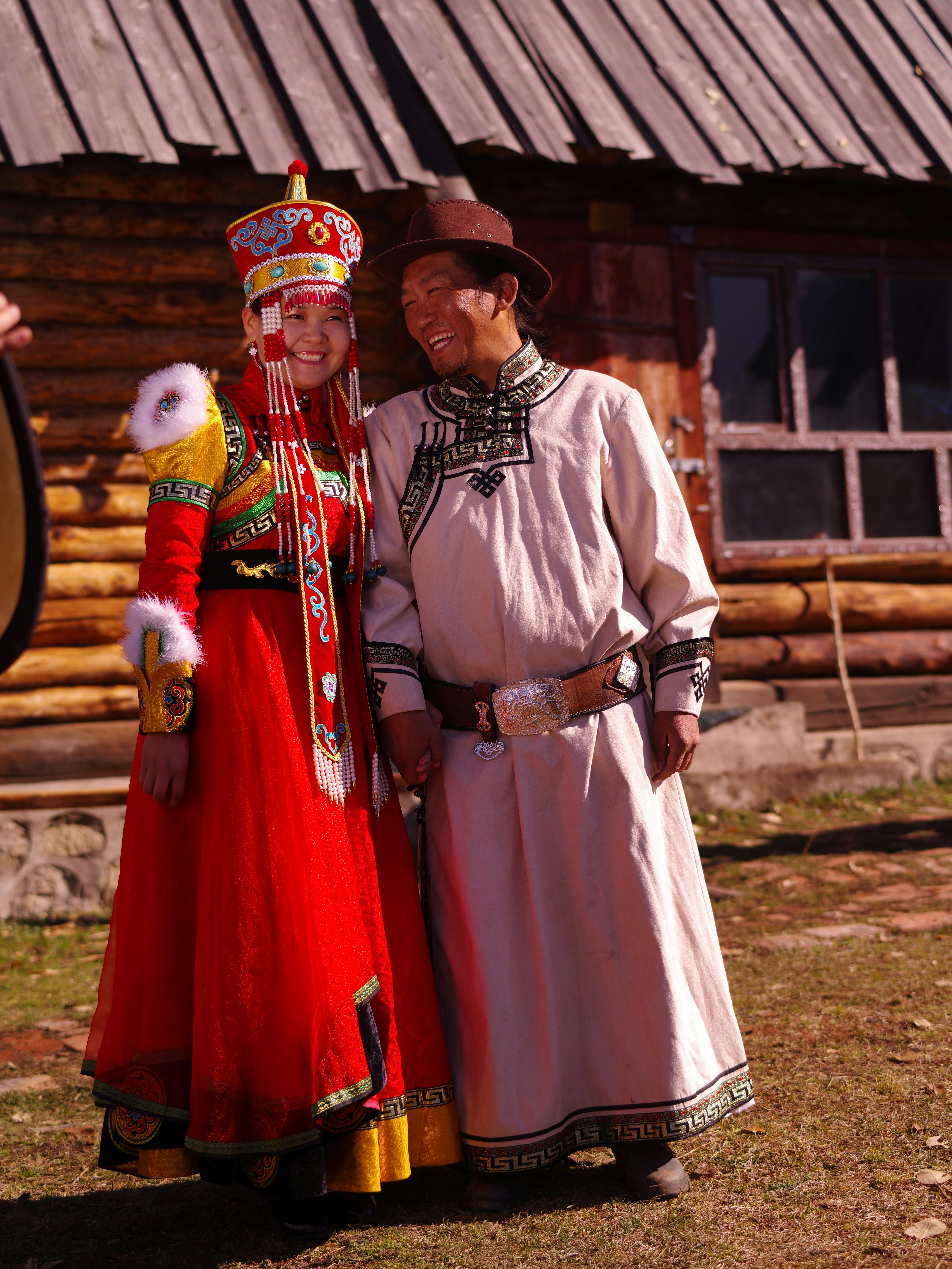 man in white and red traditional dress standing on green grass field during daytime