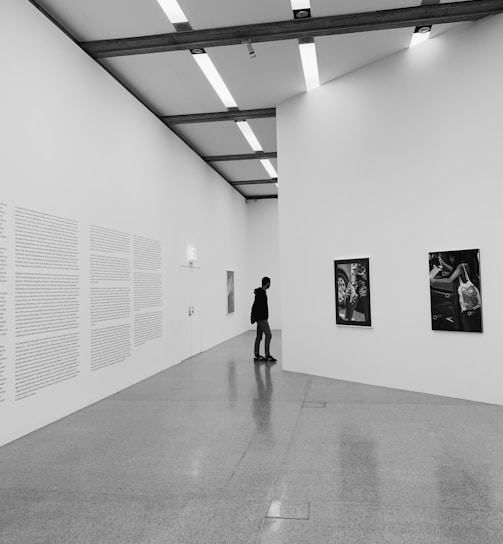 woman walking on hallway in grayscale photography