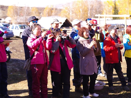 Group of photographers walking through a colorful street market with cameras.