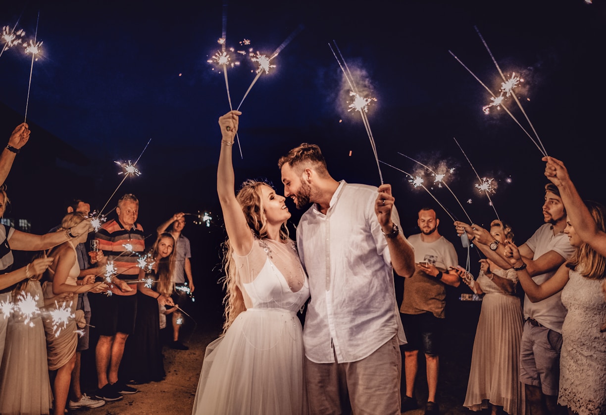 man in white dress shirt holding woman in white dress