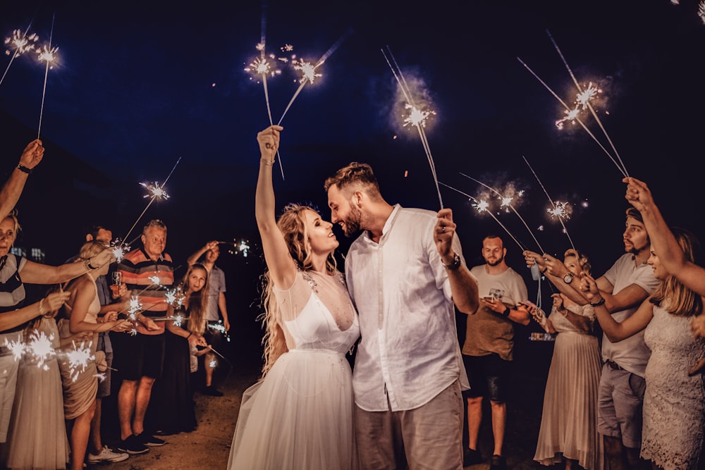 man in white dress shirt holding woman in white dress