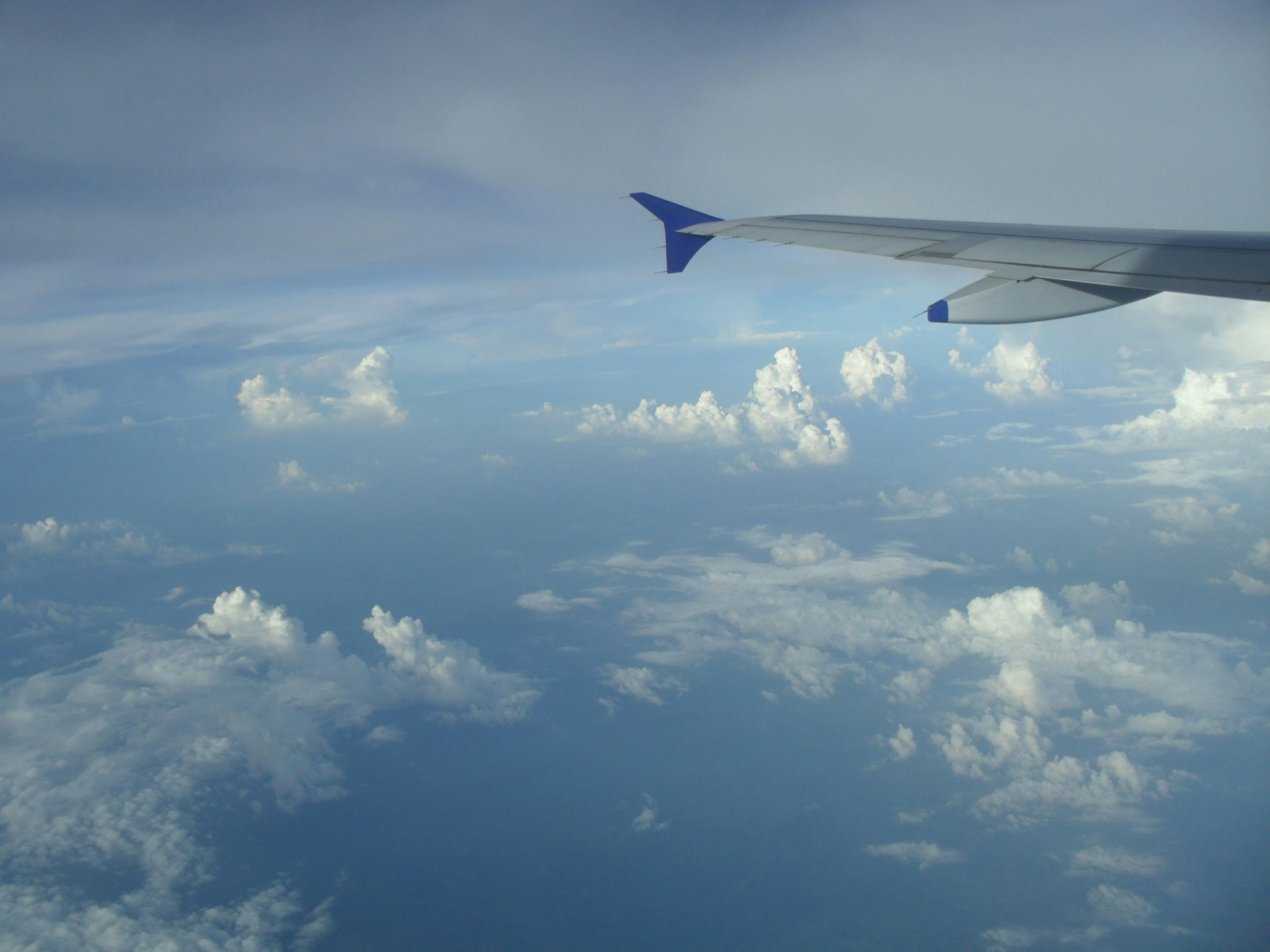 Airplane wing over clouds
