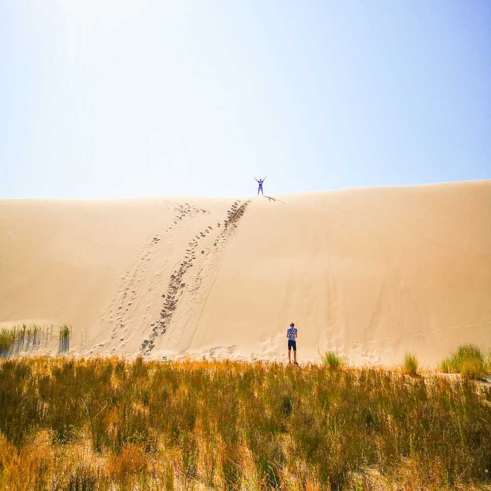 person walking on brown field during daytime