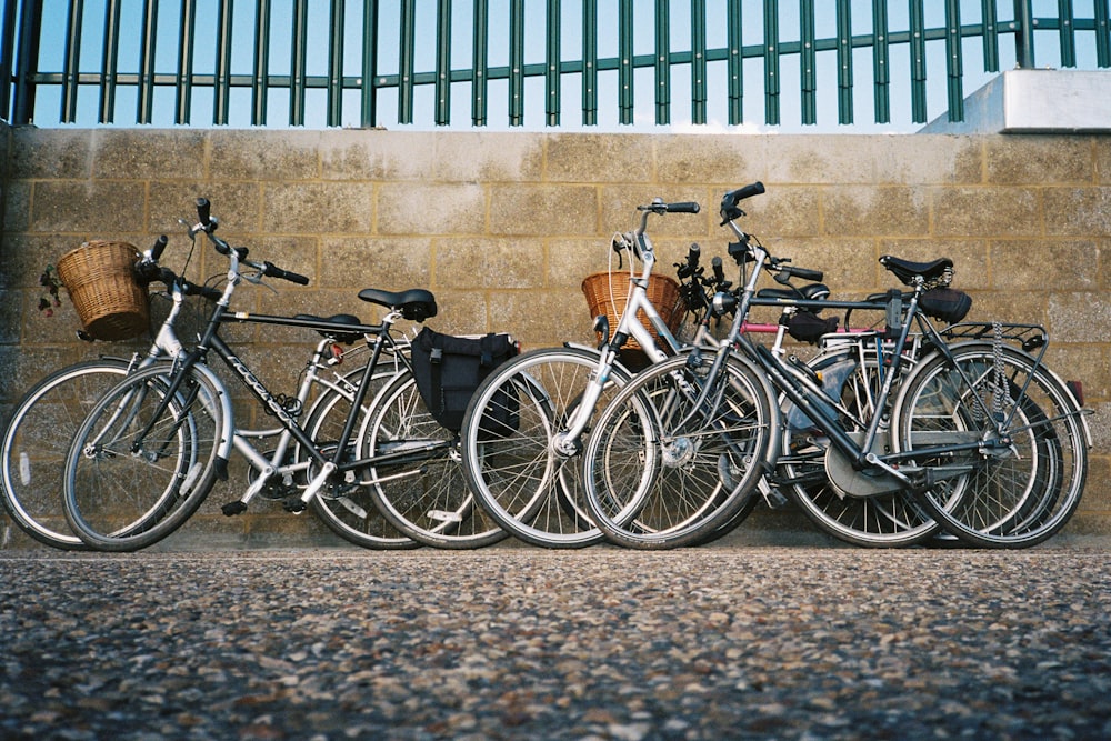 Schwarze und braune Citybikes parken tagsüber neben einem blauen Metallzaun