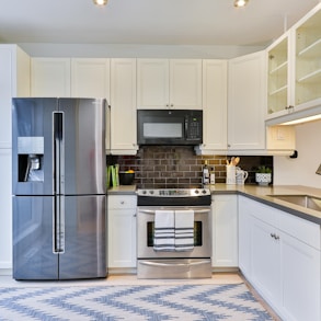 silver french door refrigerator beside white wooden kitchen cabinet