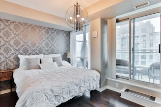 Elegant bedroom with soft lighting and plush bedding in a stylish apartment.