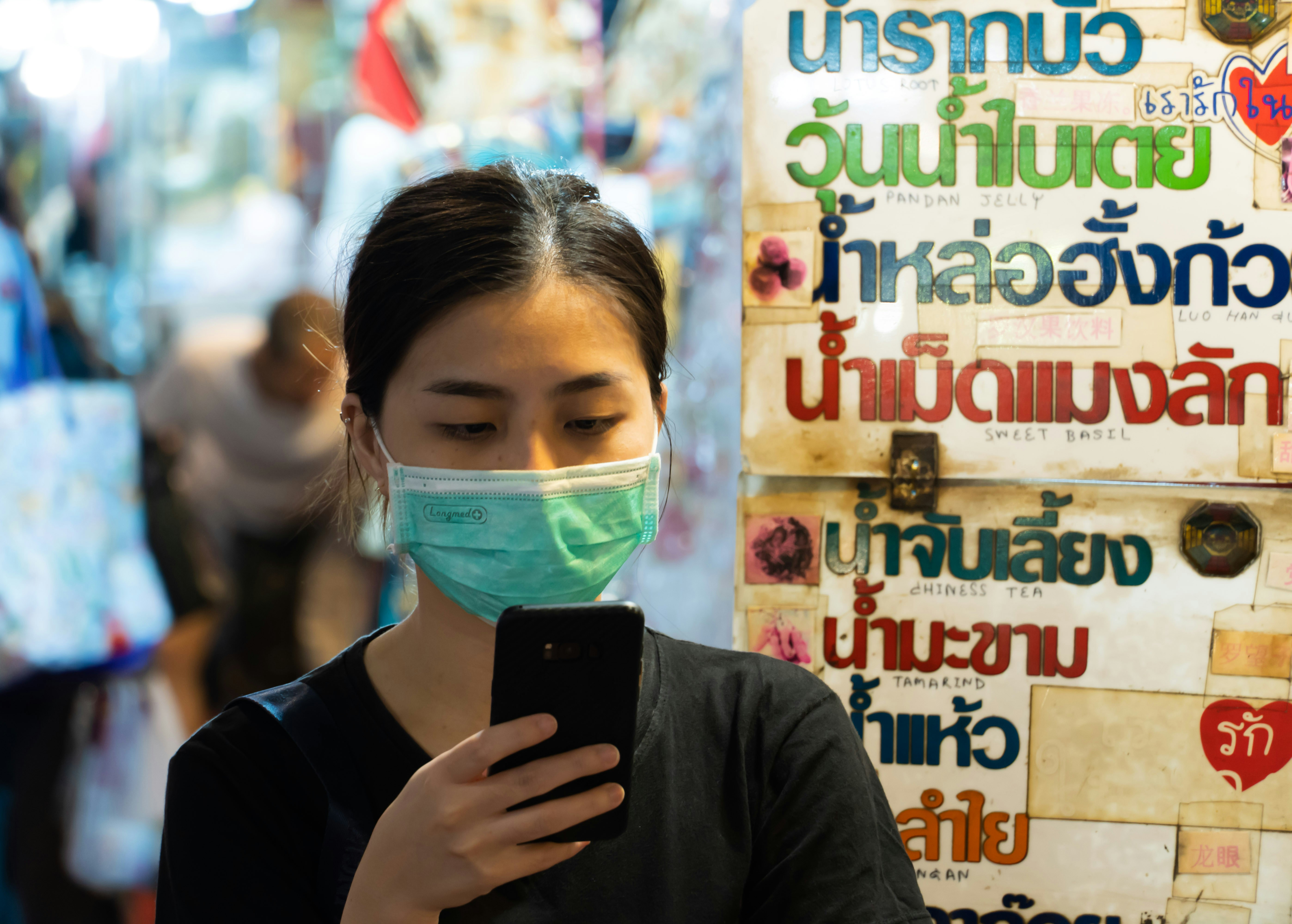 woman in black long sleeve shirt wearing white mask