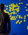 man in gray long sleeve shirt standing in front of blue and yellow puzzle mat