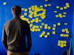 man in gray long sleeve shirt standing in front of blue and yellow puzzle mat
