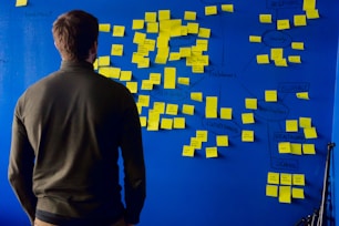 man in gray long sleeve shirt standing in front of blue and yellow puzzle mat