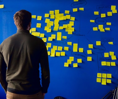 man in gray long sleeve shirt standing in front of blue and yellow puzzle mat