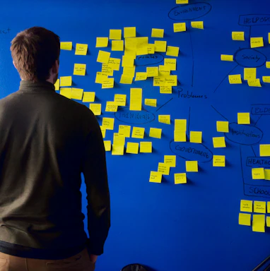 man in gray long sleeve shirt standing in front of blue and yellow puzzle mat