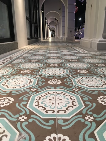 Floor tiles arranged in a geometric pattern in a spacious hallway.