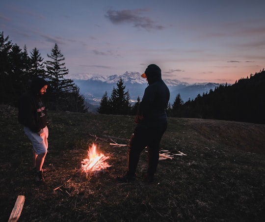 man in black jacket standing near bonfire during night time in Leysin Switzerland