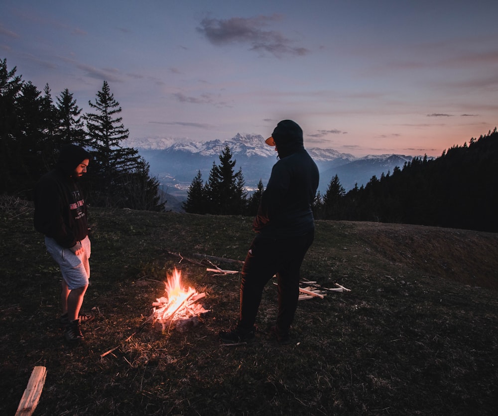 man in black jacket standing near bonfire during night time