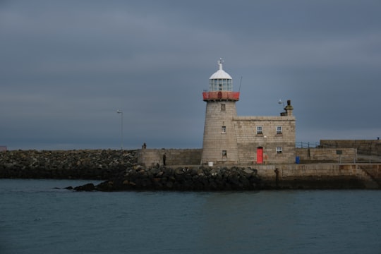 white and brown concrete building near body of water during daytime in Howth Lighthouse Ireland