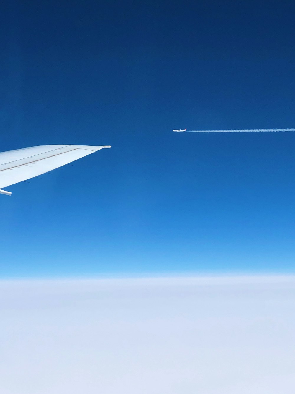white airplane wing under blue sky during daytime