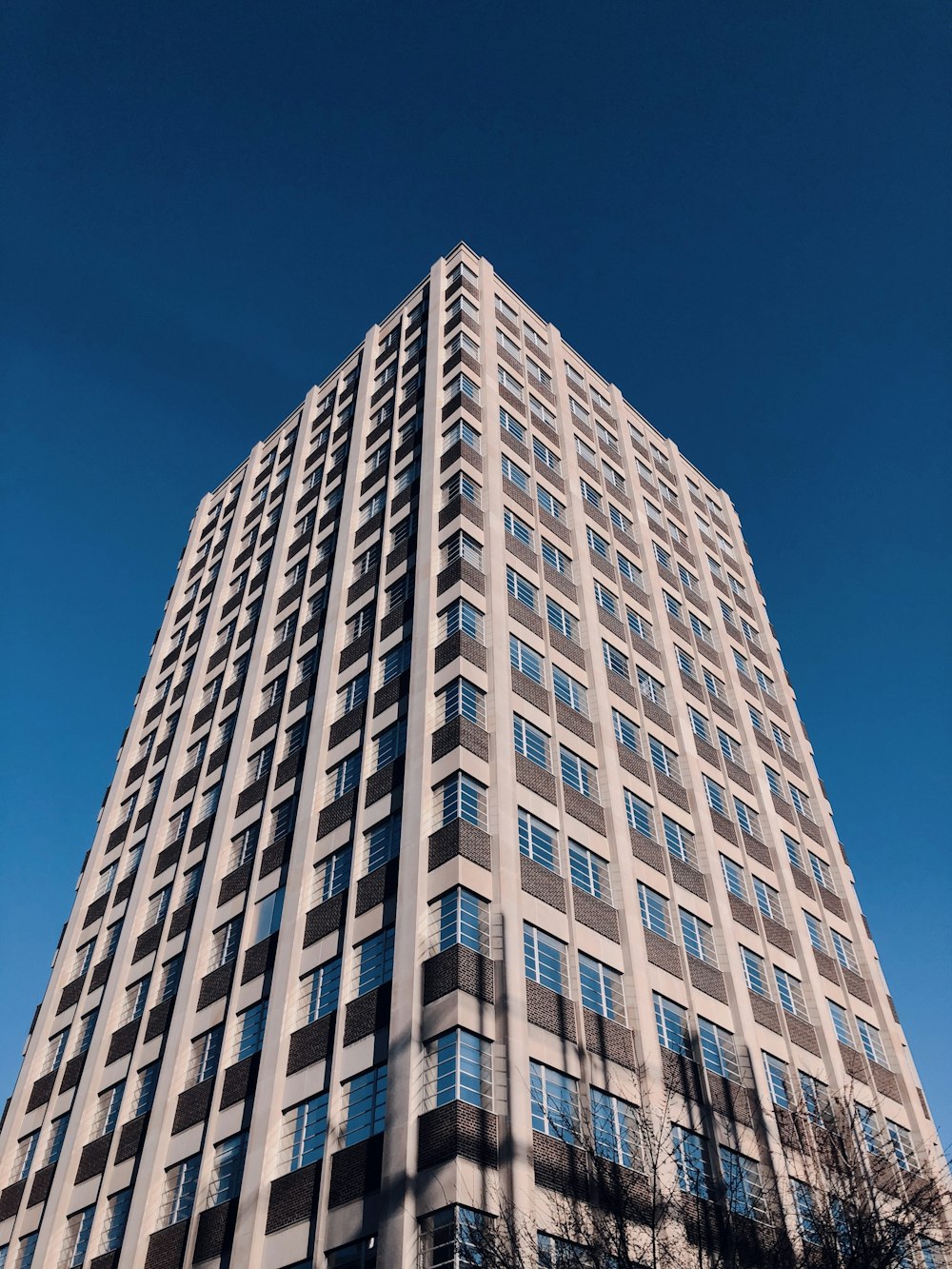 Weißes Betongebäude unter blauem Himmel tagsüber