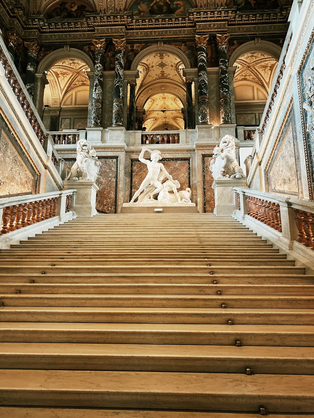 brown wooden stairs with white concrete statues