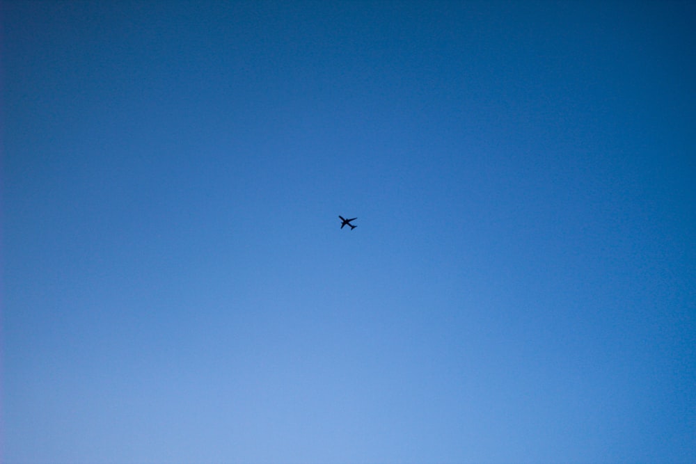 airplane in mid air under blue sky during daytime