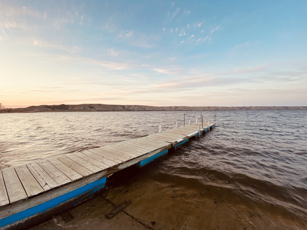 blue and white wooden boat on sea during daytime