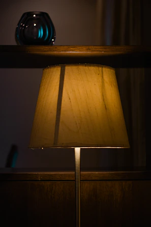 A golden-hued rustic lamp casting a warm glow in a quiet reading nook.