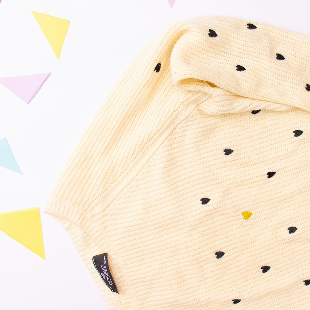 a yellow sweater with black dots on it