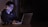 A focused individual studying stock market charts on a laptop in a dimly lit room.
