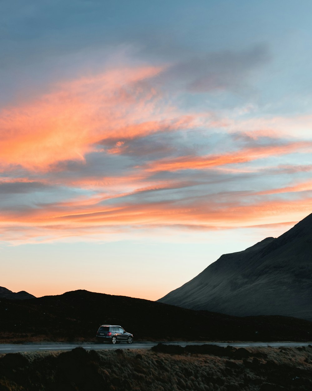 casa branca e preta perto da montanha durante o pôr do sol