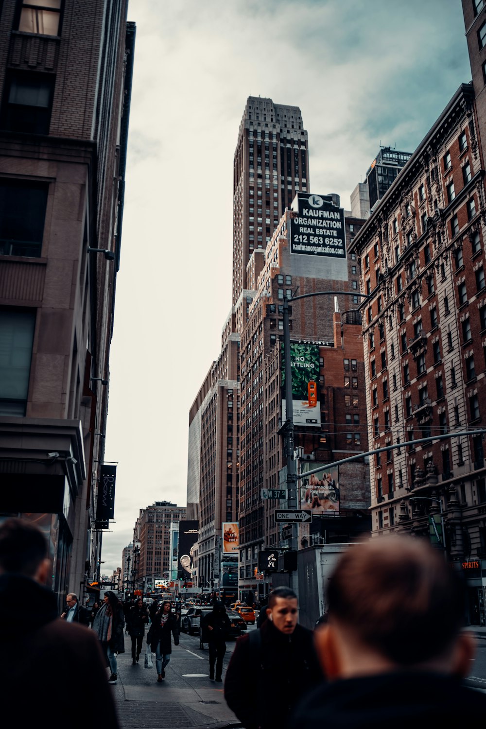 people walking on street between high rise buildings during daytime