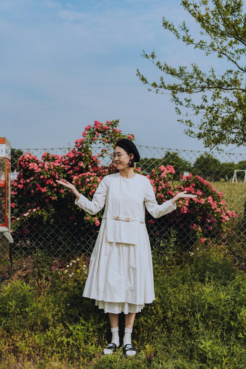 woman in white long sleeve dress standing on green grass field during daytime