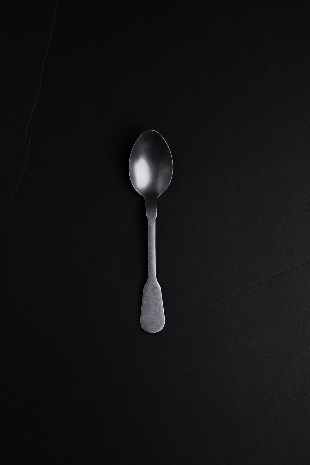 silver spoon on black textile