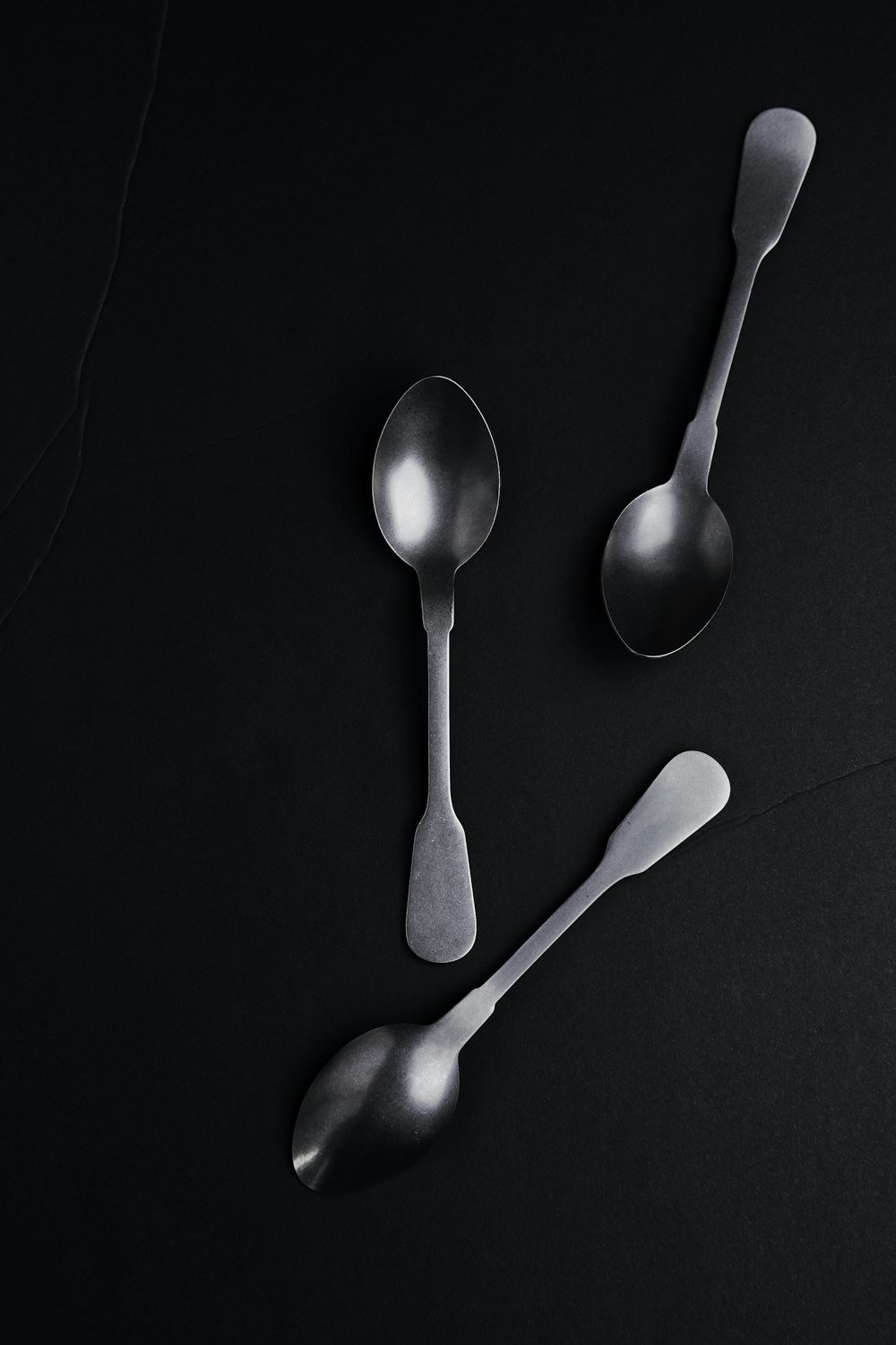 silver spoon on black surface