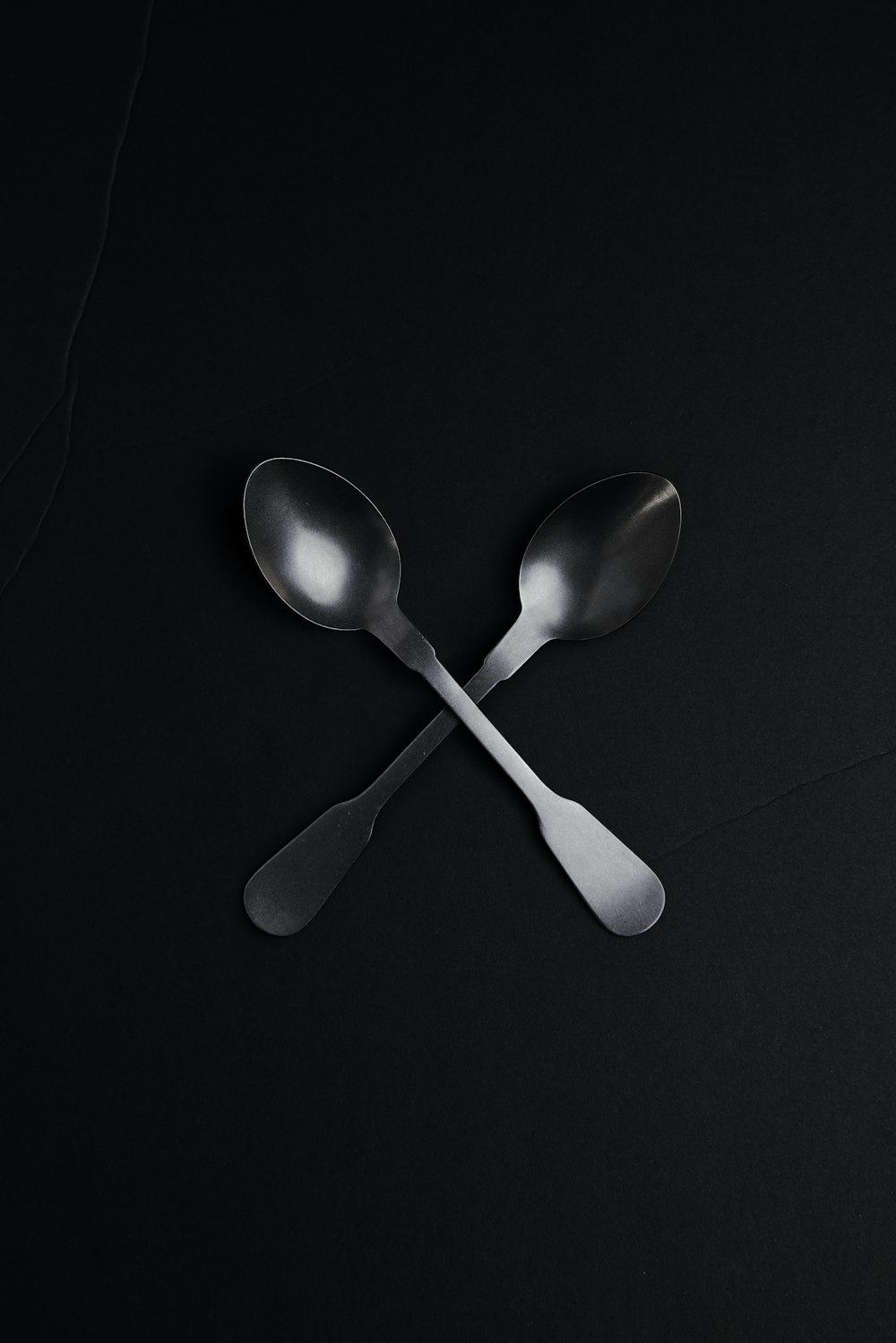 silver spoon on black textile
