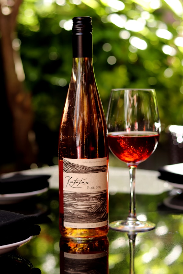 White labeled bottle beside wine glass on table