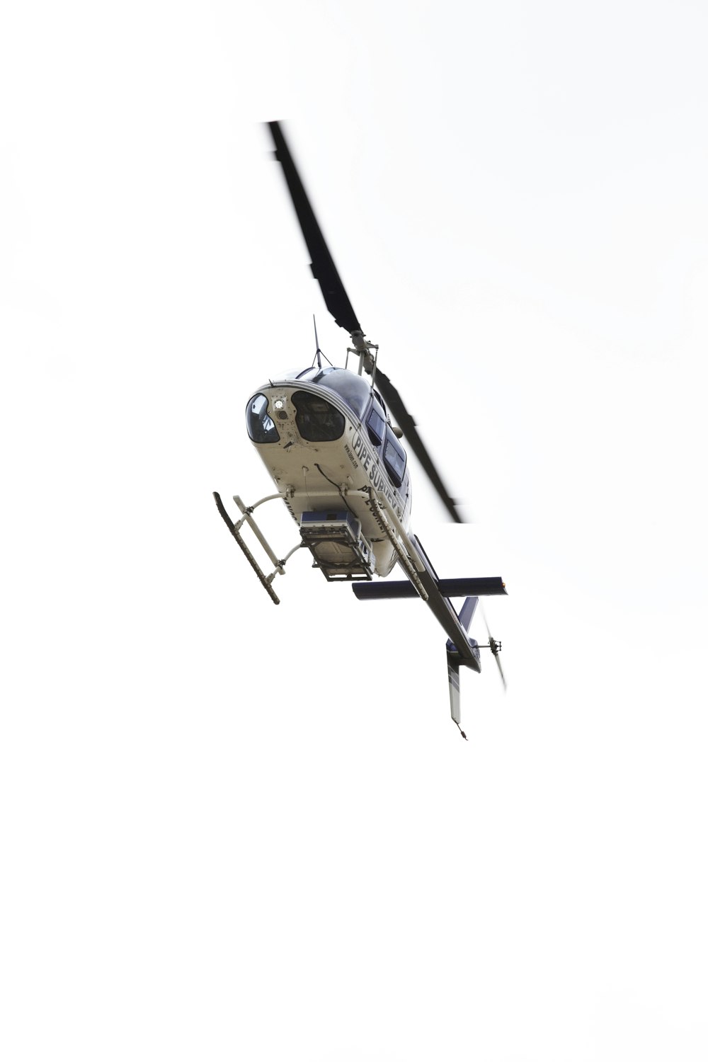 brown and black helicopter flying in the sky