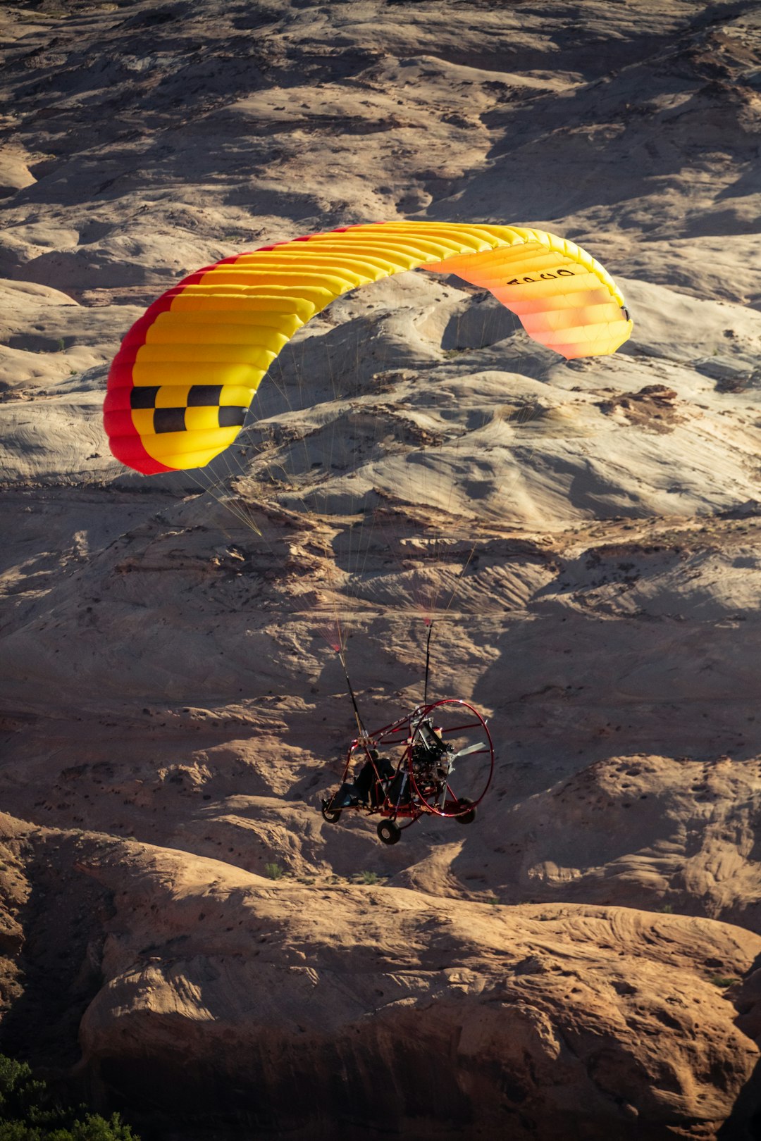 yellow red and blue parachute over gray and white mountains during daytime