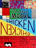 A street-smart mural backdrop behind a takeaway bag filled with chook chook chicken's signature pieces.