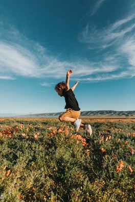 A child playing in a field of wildflowers.