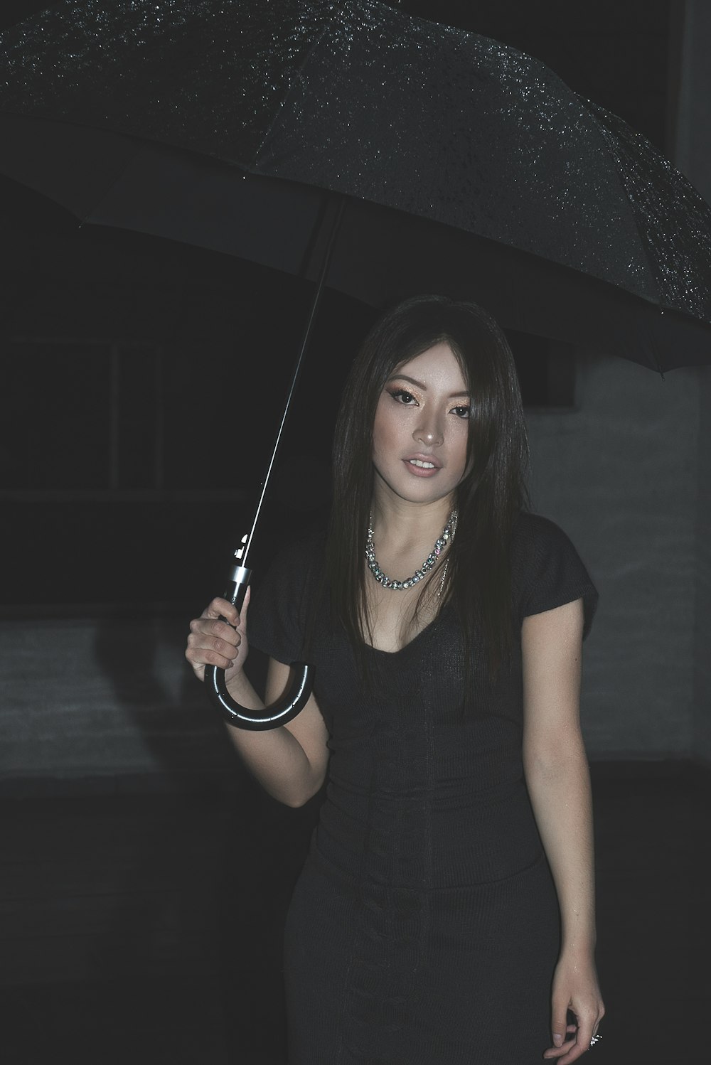 woman in black tank top holding umbrella