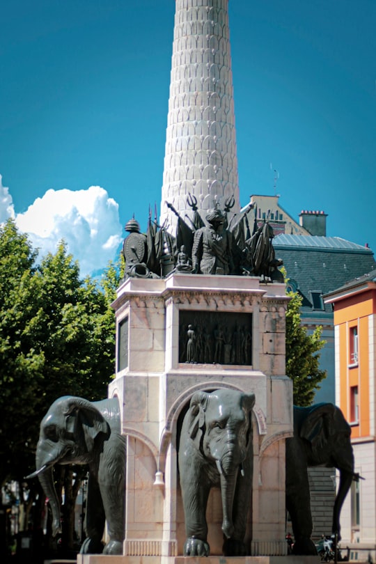 gray concrete statue near brown concrete building under blue sky during daytime in Chambéry France