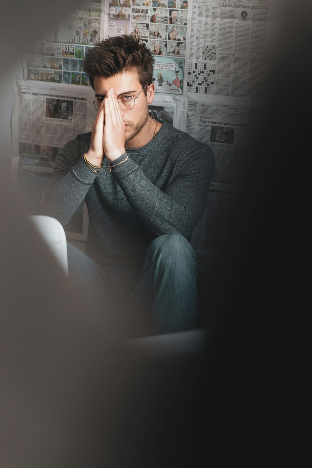 man in gray sweater sitting on black couch