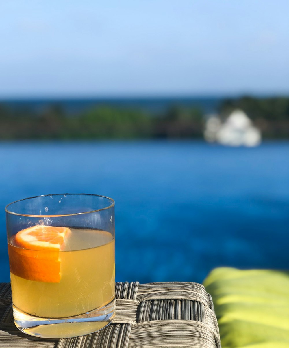 clear drinking glass with yellow liquid on table