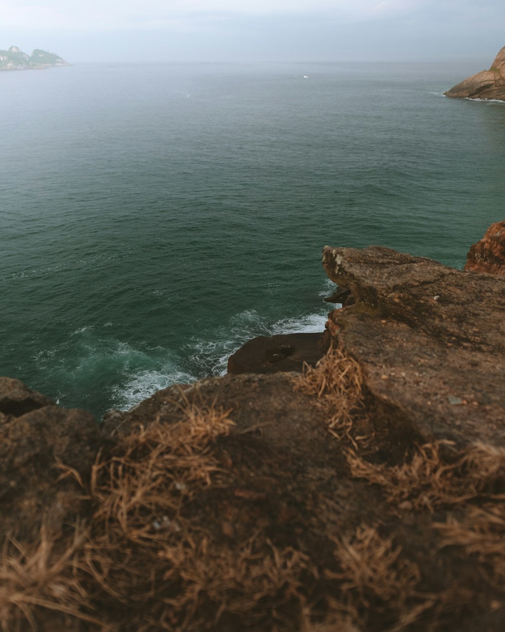 brown rock formation near body of water during daytime