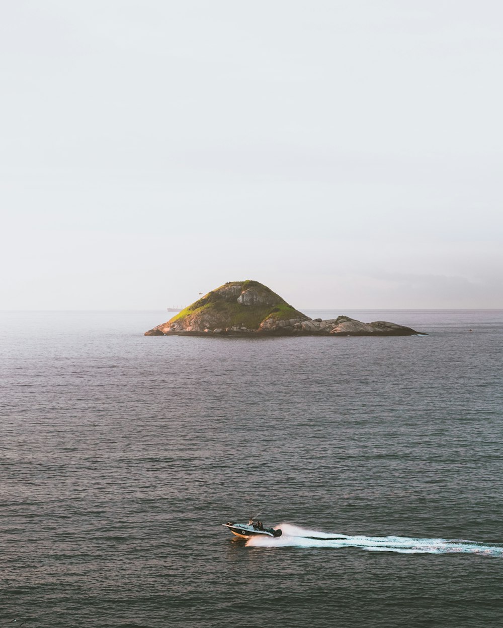 white and black boat on sea near island during daytime