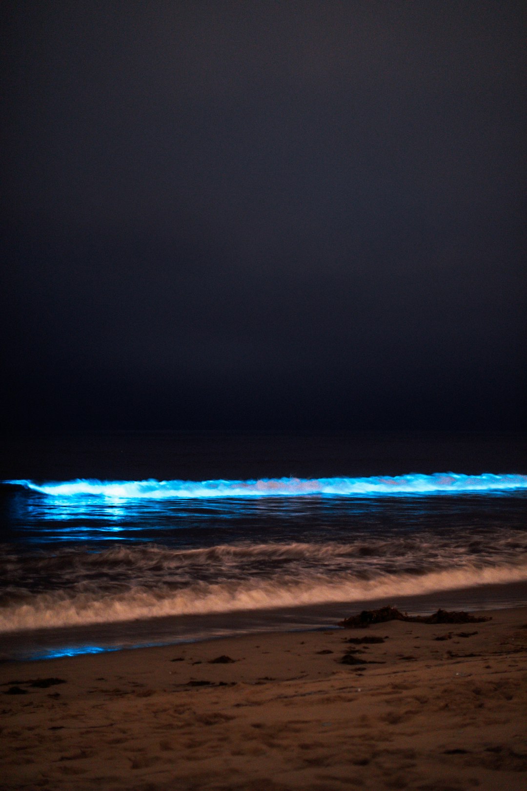 ocean waves crashing on shore during night time