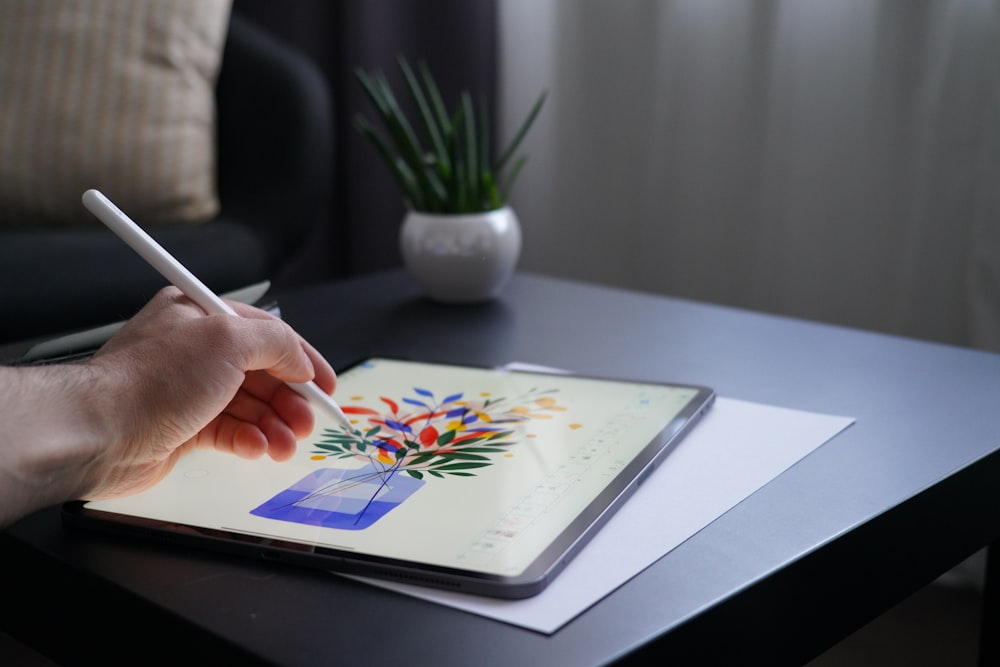 Person mit weißem Stift auf weißem Buch